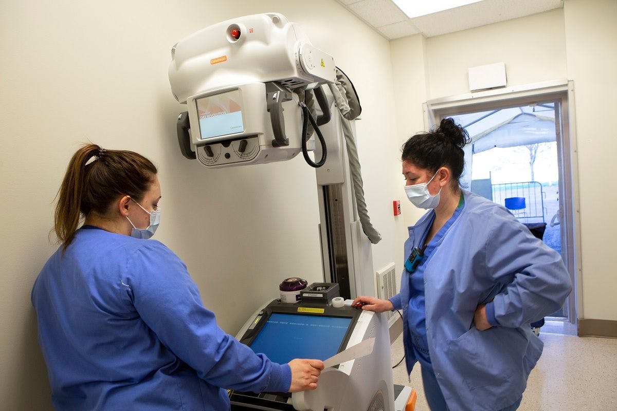 Natalie Conrad, right, and Katarina Kunkel, radiologic technologists with Penn State Health Milton S. Hershey Medical Center, set up the portable x-ray machine at 35 Hope Drive in Hershey. Courtesy: Penn State Health